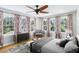 Bright bedroom featuring hardwood floors, many large windows, stylish curtains and ceiling fan at 5632 Indiana Ave, New Port Richey, FL 34652