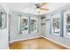 Bedroom with hardwood floors, a ceiling fan, and lots of natural light coming in through the many windows at 5632 Indiana Ave, New Port Richey, FL 34652