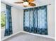 Light bedroom showcasing bright window with patterned drapes and neutral walls at 5632 Indiana Ave, New Port Richey, FL 34652