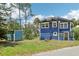 Blue two-story home with white trim, side shed, and greenery at 5632 Indiana Ave, New Port Richey, FL 34652
