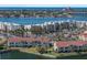 Aerial view of beachfront condos surrounded by lush landscaping, with a view of the ocean and cityscape in the distance at 6021 Bahia Del Mar Cir # 239, St Petersburg, FL 33715