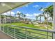 Balcony view showing the well-manicured green spaces, a swimming pool, and the waterfront at 6021 Bahia Del Mar Cir # 239, St Petersburg, FL 33715