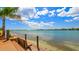 Breathtaking waterfront view with a wooden deck and bench for relaxing by the ocean on a beautiful day at 6021 Bahia Del Mar Cir # 239, St Petersburg, FL 33715