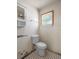Practical bathroom with a toilet, vanity, and a small window, featuring classic black and white tiled floors at 6208 Florida E Cir, Apollo Beach, FL 33572