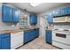 Bright kitchen features blue cabinets, white appliances, tile flooring, and gray walls at 6208 Florida E Cir, Apollo Beach, FL 33572