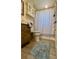 Cozy bathroom featuring a vanity with storage, neutral tile flooring, and a shower with patterned curtain at 6235 17Th N Ave, St Petersburg, FL 33710