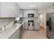 Updated kitchen featuring granite counters, stainless steel appliances, tile floors, and gray shaker cabinets at 6235 17Th N Ave, St Petersburg, FL 33710