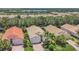 Overhead view showcases houses with terracotta roofs, mature trees, and a peaceful community lake at 6315 43Rd E Ct, Sarasota, FL 34243