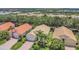 Overhead shot showcases houses with terracotta tile roofs, palm trees, and well-kept lawns near a tranquil lake at 6315 43Rd E Ct, Sarasota, FL 34243