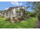 Well-maintained backyard with lush green grass, tropical plants, and a privacy screen at 6315 43Rd E Ct, Sarasota, FL 34243