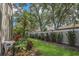 Beautiful backyard with tropical landscaping, green grass, and a partial view of a privacy fence at 6315 43Rd E Ct, Sarasota, FL 34243