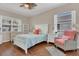 Well-lit bedroom with ceiling fan, wood flooring, and two bright windows for an airy and comfortable atmosphere at 6315 43Rd E Ct, Sarasota, FL 34243