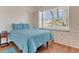 Bedroom with a blue comforter, wood floors, and bright light from a large window creating a warm space at 6315 43Rd E Ct, Sarasota, FL 34243