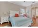 Cozy bedroom with an orange accent pillow, wood flooring, and a large window offering natural light at 6315 43Rd E Ct, Sarasota, FL 34243