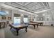 Community billiards room with coffered ceilings, pendant lighting, and three tables covered at 6315 43Rd E Ct, Sarasota, FL 34243