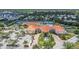 Aerial view of a community clubhouse with tennis courts, a pool, lush landscaping, and ample parking, enhancing the community appeal at 6315 43Rd E Ct, Sarasota, FL 34243