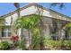 Exterior view of the home featuring mature landscaping, a screened lanai, and neutral color palette at 6315 43Rd E Ct, Sarasota, FL 34243