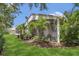 Exterior of a home with a screened-in lanai, lush landscaping, and a well-manicured lawn at 6315 43Rd E Ct, Sarasota, FL 34243