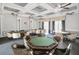 Well-lit game room with multiple gaming tables, elegant chairs, and coffered ceilings with fans at 6315 43Rd E Ct, Sarasota, FL 34243
