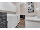 Bright laundry room with a utility sink, washer, dryer, storage cabinets, and wood-look flooring at 6315 43Rd E Ct, Sarasota, FL 34243
