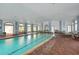 Indoor pool area with lounge chairs, brick flooring, and large arched windows providing plenty of light at 6315 43Rd E Ct, Sarasota, FL 34243
