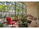 This cozy sunroom has brick floors and is fully furnished with sofa and seating. It has a beautiful view and privacy at 6315 43Rd E Ct, Sarasota, FL 34243