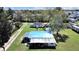 Aerial view of the white home with blue roof and overgrown lawn on a sunny day at 6673 146Th N Ave, Clearwater, FL 33764