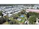 A mobile home park featuring multiple homes with white roofs, manicured lawns, and community lake at 6673 146Th N Ave, Clearwater, FL 33764