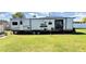 Exterior of the Wildwood DLX Trailer in a well-maintained grassy area with a blue sky at 6673 146Th N Ave, Clearwater, FL 33764