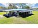 Exterior view of the white home with cluttered porch on a sunny day at 6673 146Th N Ave, Clearwater, FL 33764