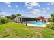 Spacious backyard featuring a sparkling pool, covered patio, and well-maintained lawn at 6903 Cedar Ridge N Dr, Pinellas Park, FL 33781