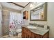 Bathroom with wooden vanity, granite countertop, tiled shower and decorative floral shower curtain at 6903 Cedar Ridge N Dr, Pinellas Park, FL 33781