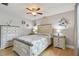 Bedroom with light wood floors, coastal decor, and a ceiling fan at 6903 Cedar Ridge N Dr, Pinellas Park, FL 33781