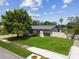 Well-manicured front lawn and garden enhance this single-story home's curb appeal, complemented by a white privacy fence at 6903 Cedar Ridge N Dr, Pinellas Park, FL 33781