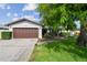 Charming single-story home with a well-maintained lawn and brown garage door, complemented by a mature, shady tree at 6903 Cedar Ridge N Dr, Pinellas Park, FL 33781