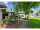 Charming single-story home featuring a decorative front garden, brick walkway, and trimmed hedges for enhanced curb appeal at 6903 Cedar Ridge N Dr, Pinellas Park, FL 33781