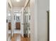 Hallway with multiple mirror-fronted storage closets and wood floors, leading to the bathroom at 6903 Cedar Ridge N Dr, Pinellas Park, FL 33781