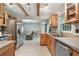Well-lit kitchen with stainless steel appliances, natural wood cabinetry, and exposed beams at 6903 Cedar Ridge N Dr, Pinellas Park, FL 33781