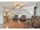Open-concept living room with hardwood floors, comfortable seating, and bright lighting, perfect for relaxing and entertaining at 6903 Cedar Ridge N Dr, Pinellas Park, FL 33781