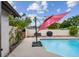 Backyard pool area with updated pool deck, grill, and red sun umbrella at 6903 Cedar Ridge N Dr, Pinellas Park, FL 33781
