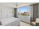 Bedroom with ceiling fan, and scenic views of the Don CeSar Hotel through a large window at 700 Beach Ne Dr # 704, St Petersburg, FL 33701