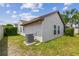 Green backyard with an AC unit placed on a concrete foundation at 7035 Drury St, Tampa, FL 33635