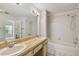 Well-lit bathroom featuring dual sinks, a large mirror, and a shower-tub combination at 7035 Drury St, Tampa, FL 33635
