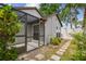 Cozy screened-in porch with lush greenery and charming stone walkway at 7035 Drury St, Tampa, FL 33635