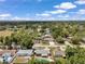 Aerial view of a home featuring mature trees, a backyard pool and patio, and well-maintained landscaping at 8497 Portulaca Ave, Seminole, FL 33777