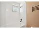 Bright bathroom featuring a tiled shower with a window for natural light at 8497 Portulaca Ave, Seminole, FL 33777