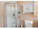 Bathroom featuring a standing shower, toilet, and white storage cabinet providing ample storage space at 8497 Portulaca Ave, Seminole, FL 33777