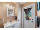Bright bathroom with vanity, a charming fish decoration, and a doorway to the outside with natural light at 8497 Portulaca Ave, Seminole, FL 33777