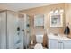 Neutral toned bathroom featuring a shower, toilet, vanity and beach themed artwork at 8497 Portulaca Ave, Seminole, FL 33777
