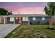 Inviting home exterior at dusk, highlighting a cozy front yard and quaint architectural details at 8497 Portulaca Ave, Seminole, FL 33777